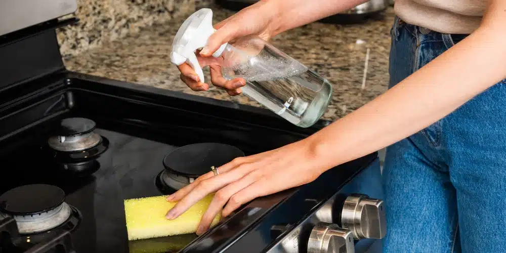 cleaning the stovetop in the kitchen