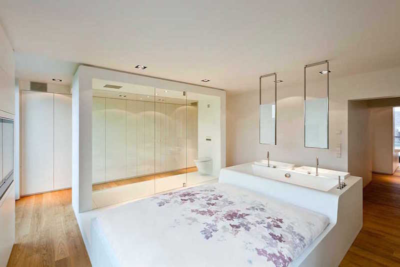 open-concept bathroom inside a bedroom with a bathtub headboard